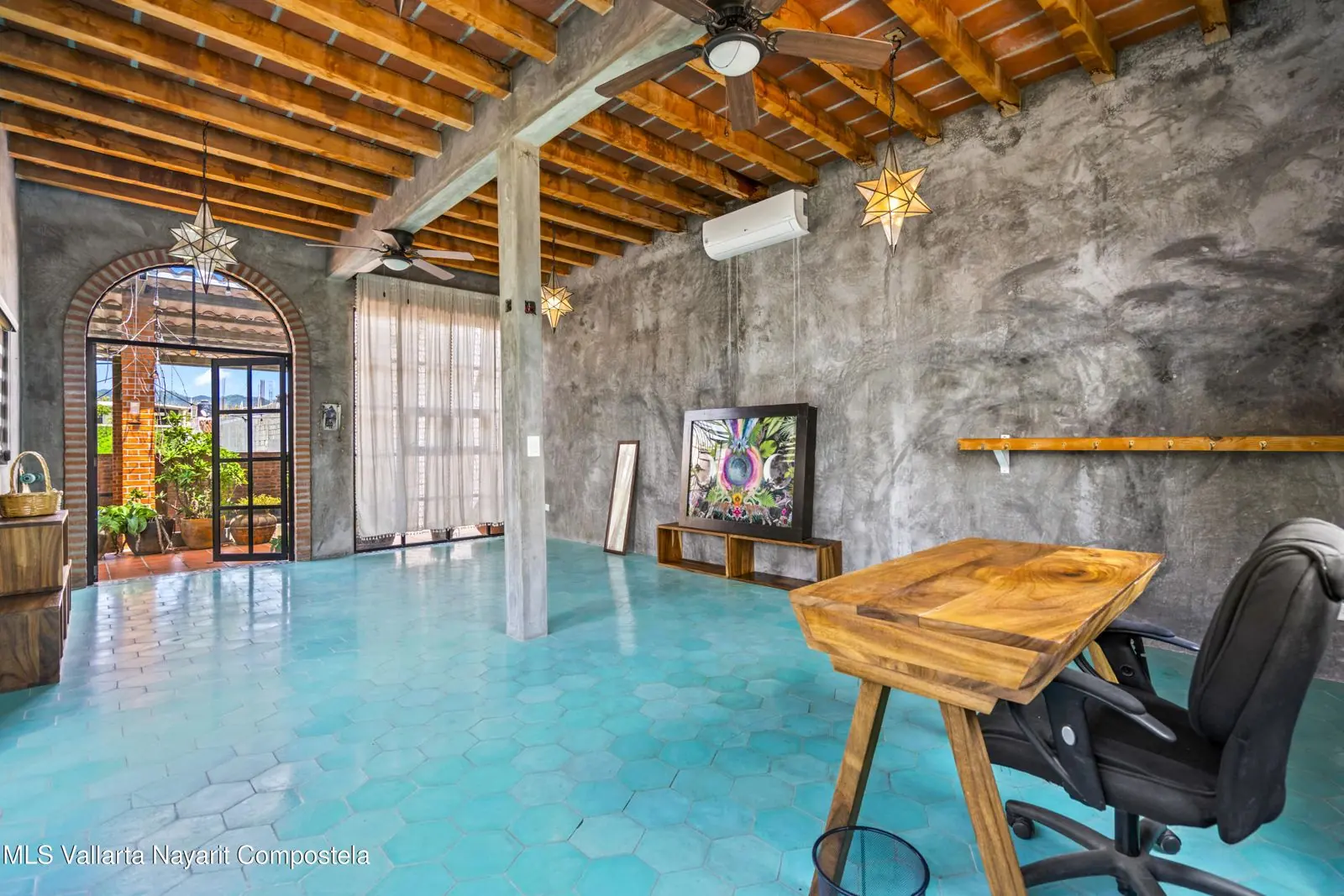 Living room of Casa Cósmica in La Cruz, with a brick-vault ceiling, a turquoise floor, and white sofas.