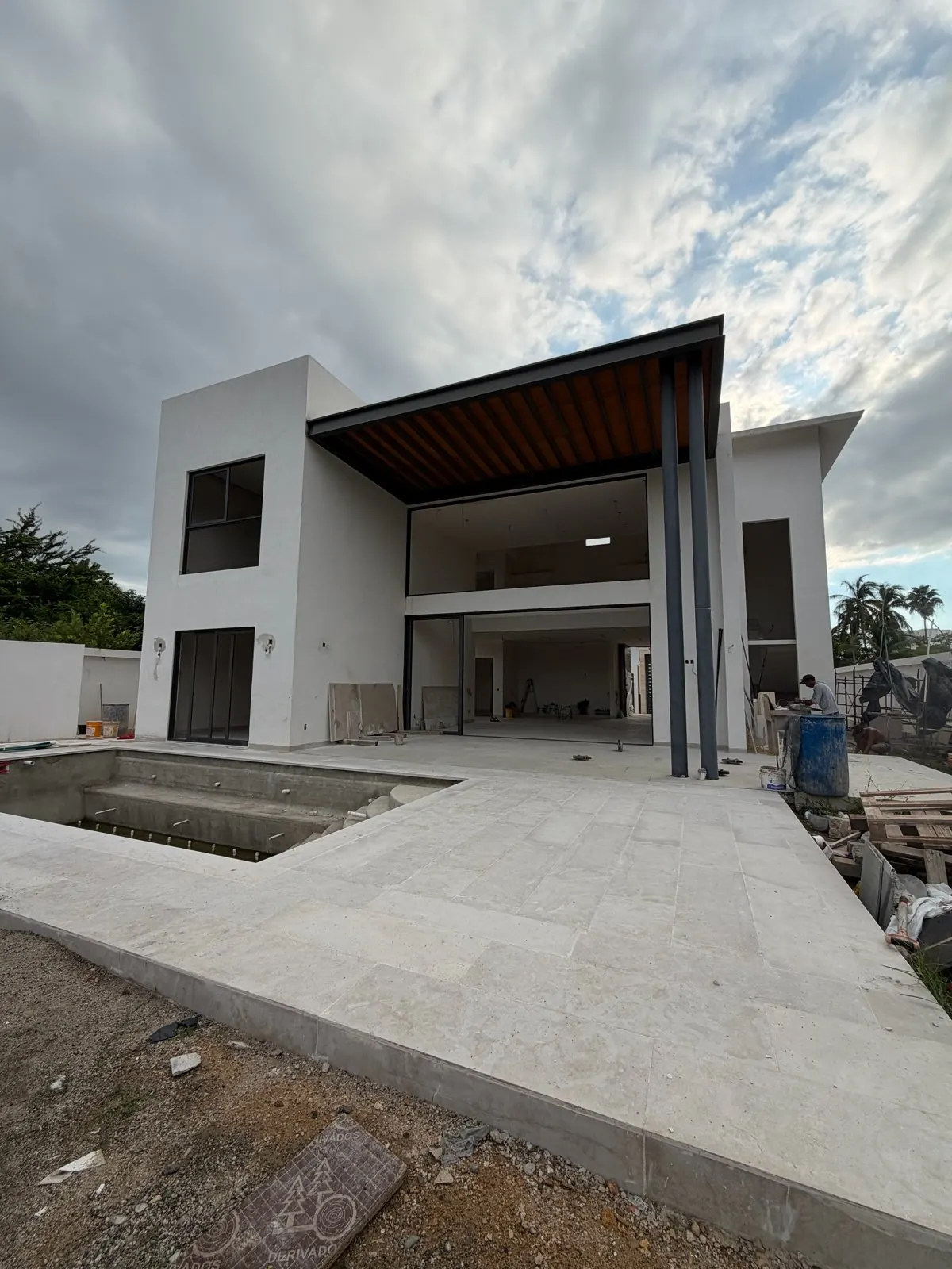 Real photo, Oct 2026. Corner facade from the street, with large windows, the main gate and the front wall.