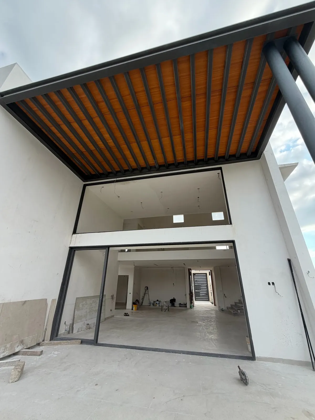 Real photo, Oct 2026. Front garden, gate and facade with floor-to-ceiling windows.