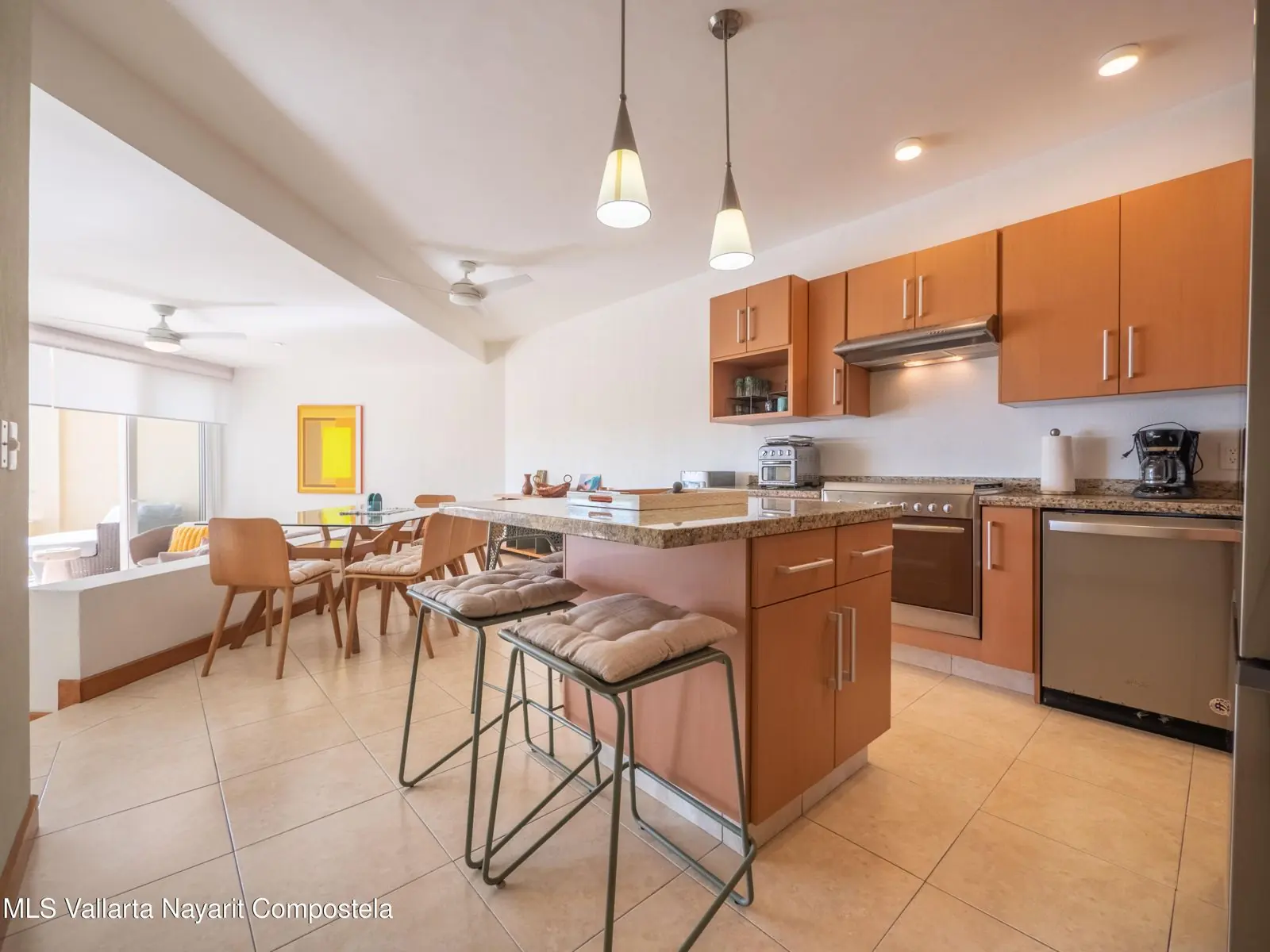 Kitchen of Colibrí de Mita 208, with white cabinets and a wood island.